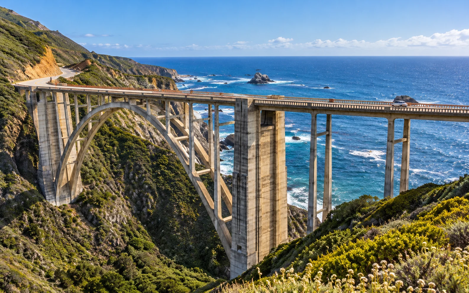 Illustrative Bixby-style arch bridge along the Big Sur coast; not a documentary photograph